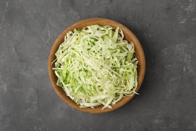 Chopped cabbage in bowl on grey table, top view