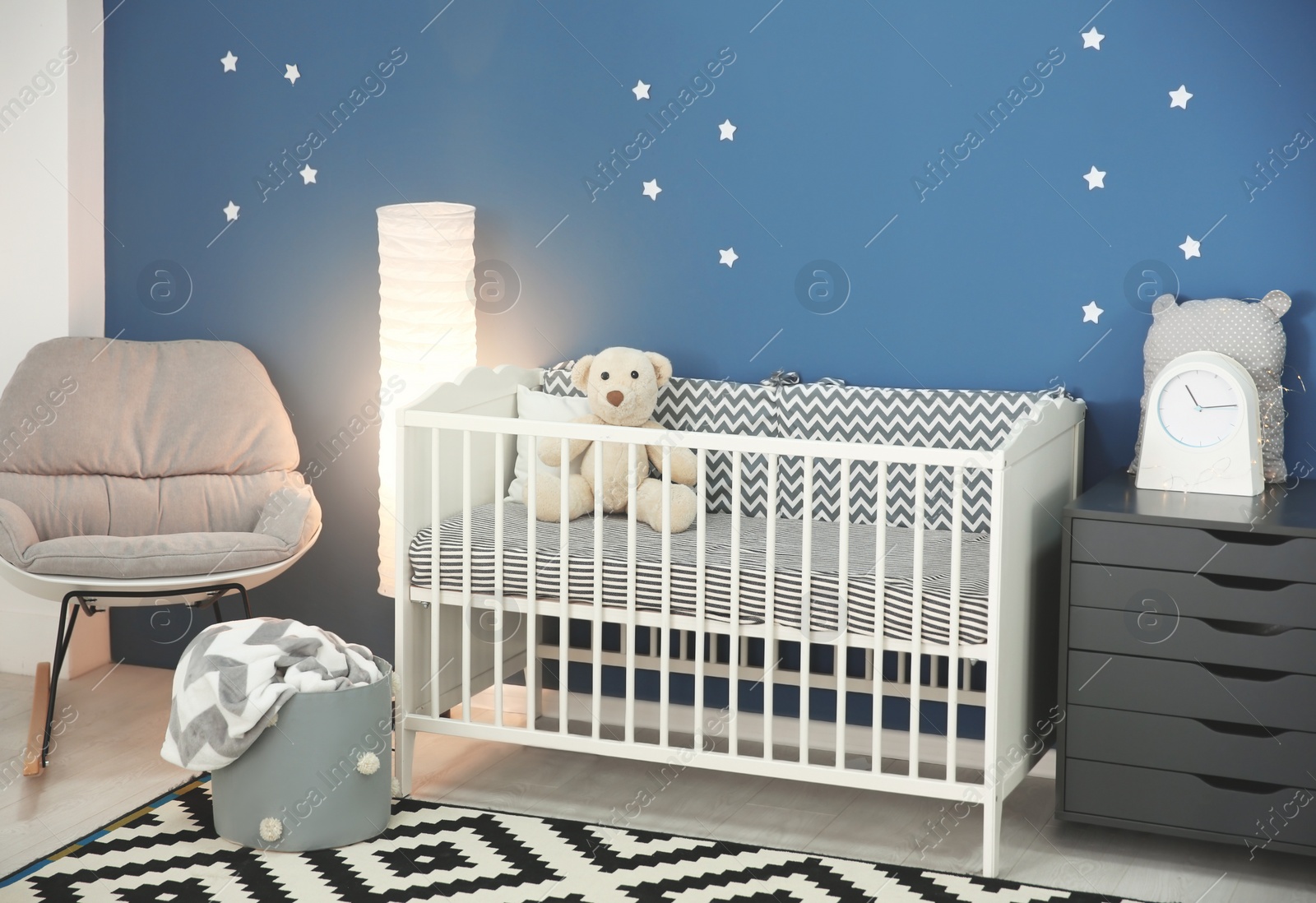 Photo of Baby room interior with comfortable crib and rocking chair