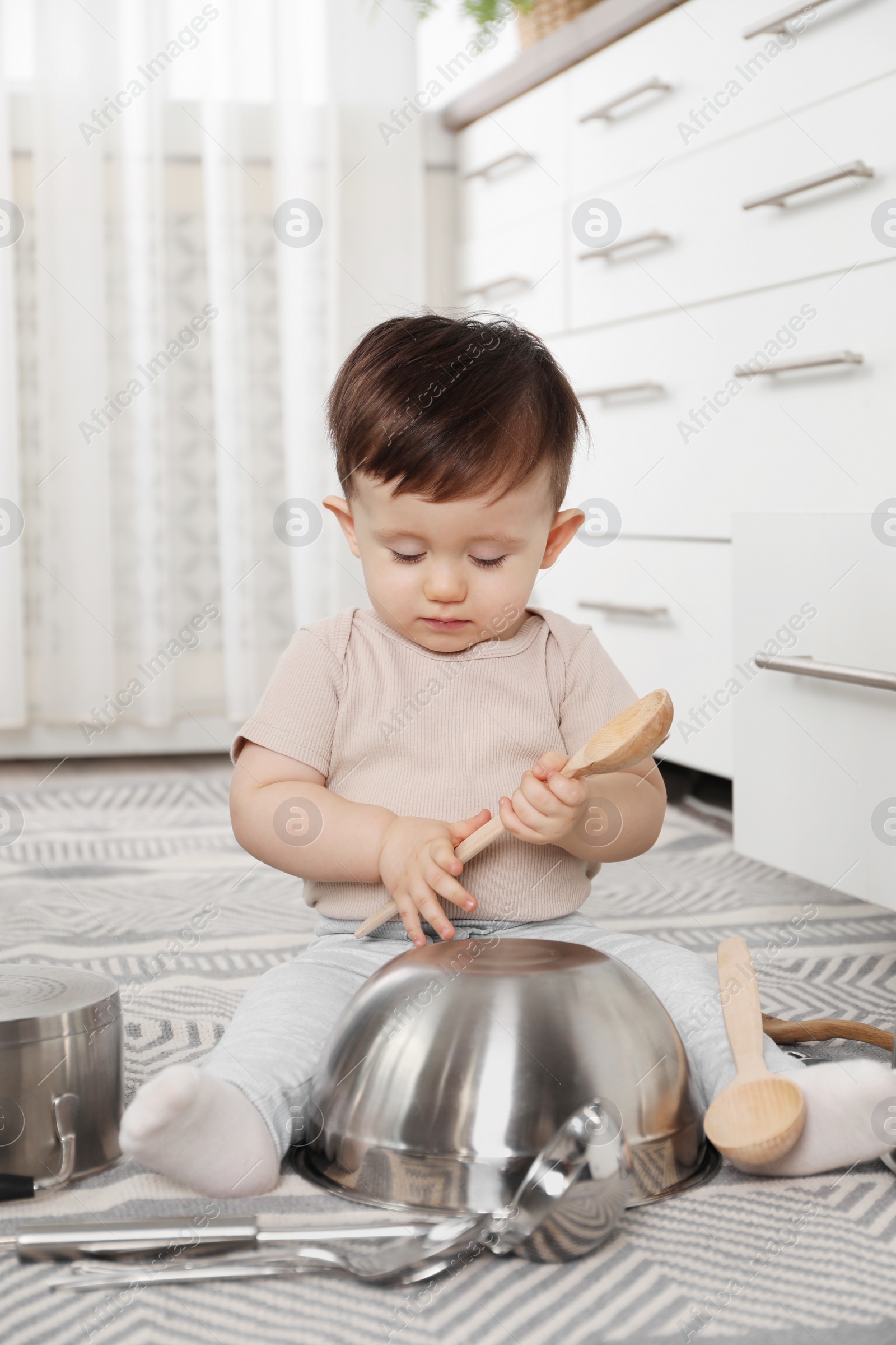 Photo of Cute little boy with cookware at home