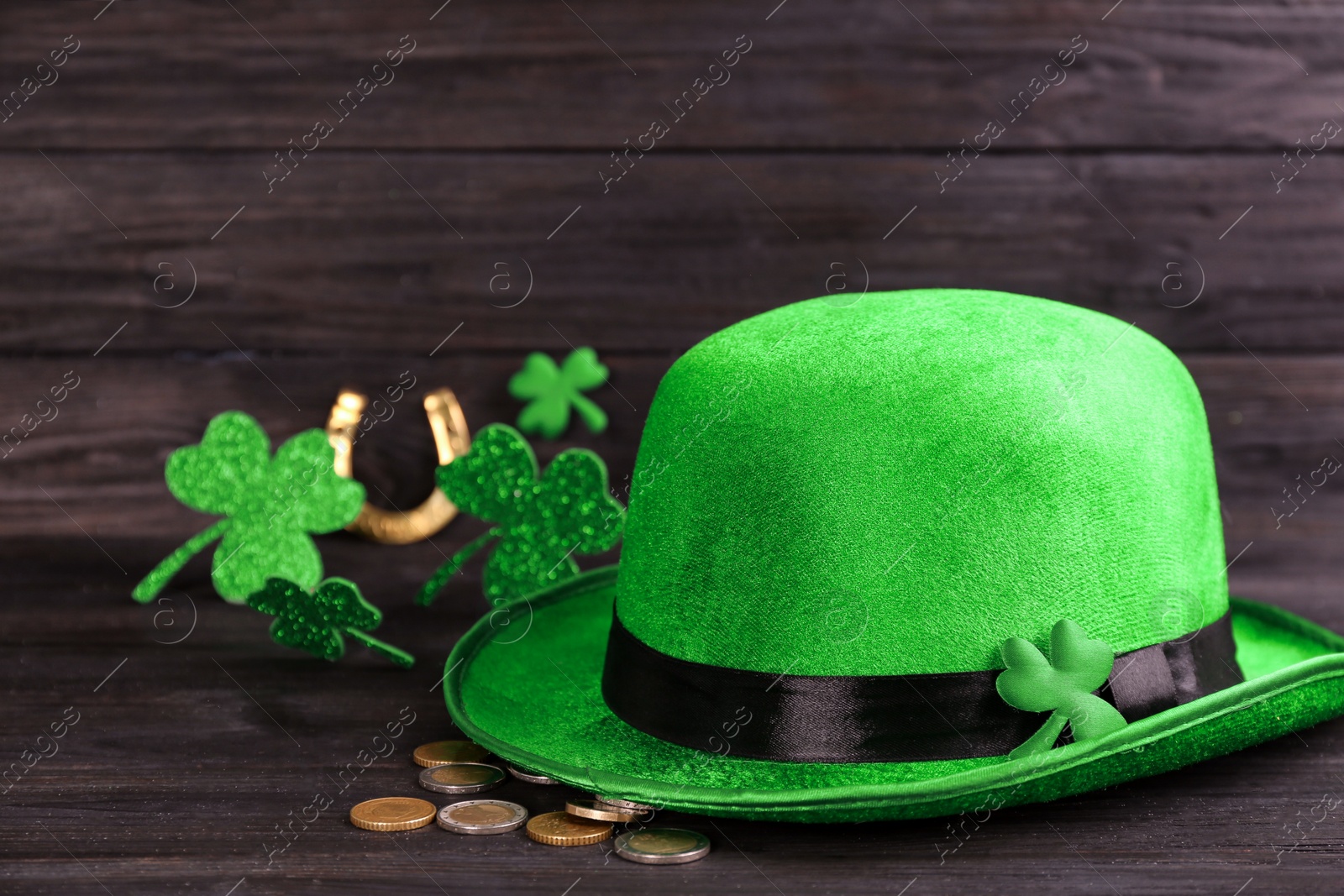 Photo of Leprechaun's hat and St. Patrick's day decor on black wooden table