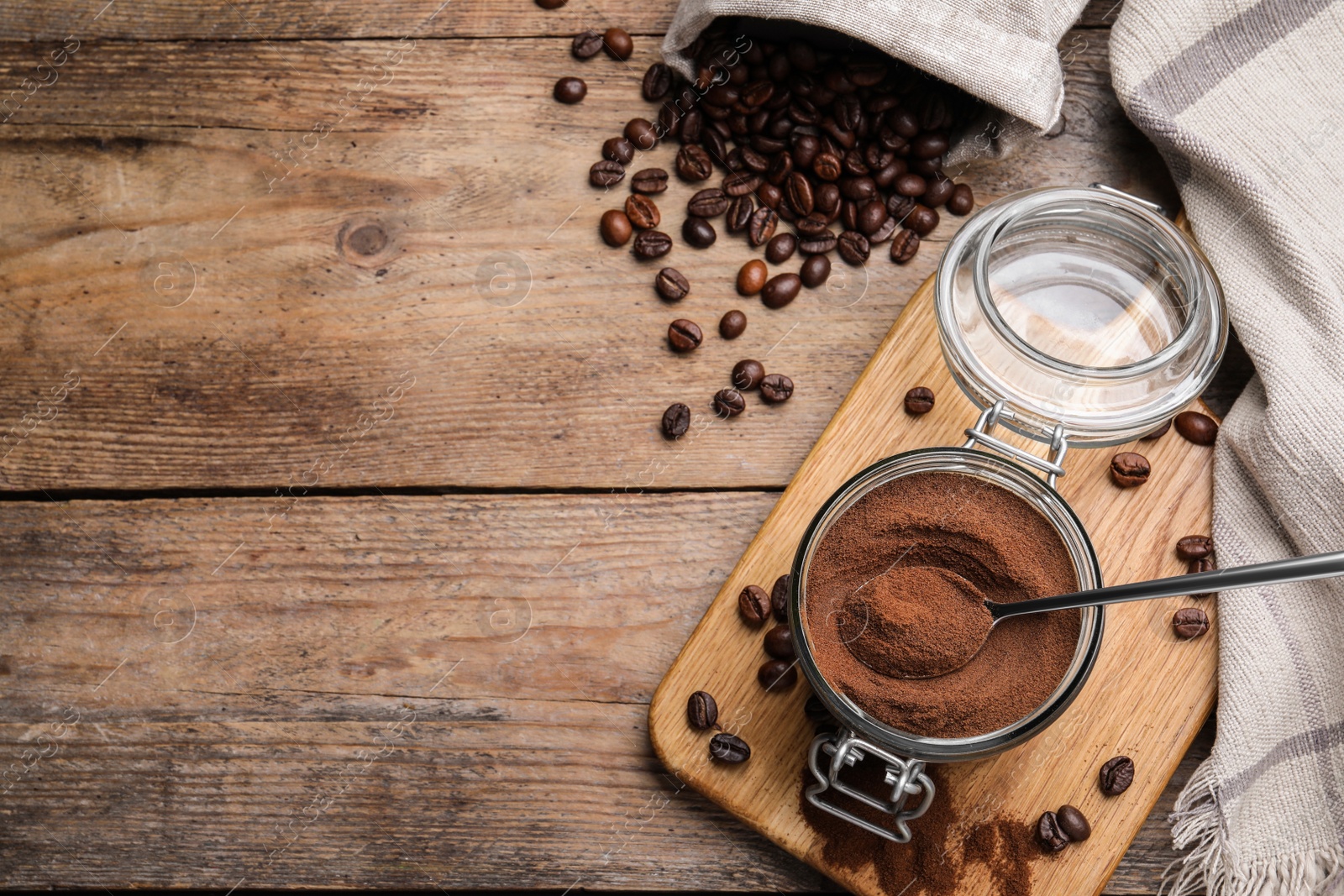 Photo of Glass jar of instant coffee and spoon on wooden table, flat lay. Space for text