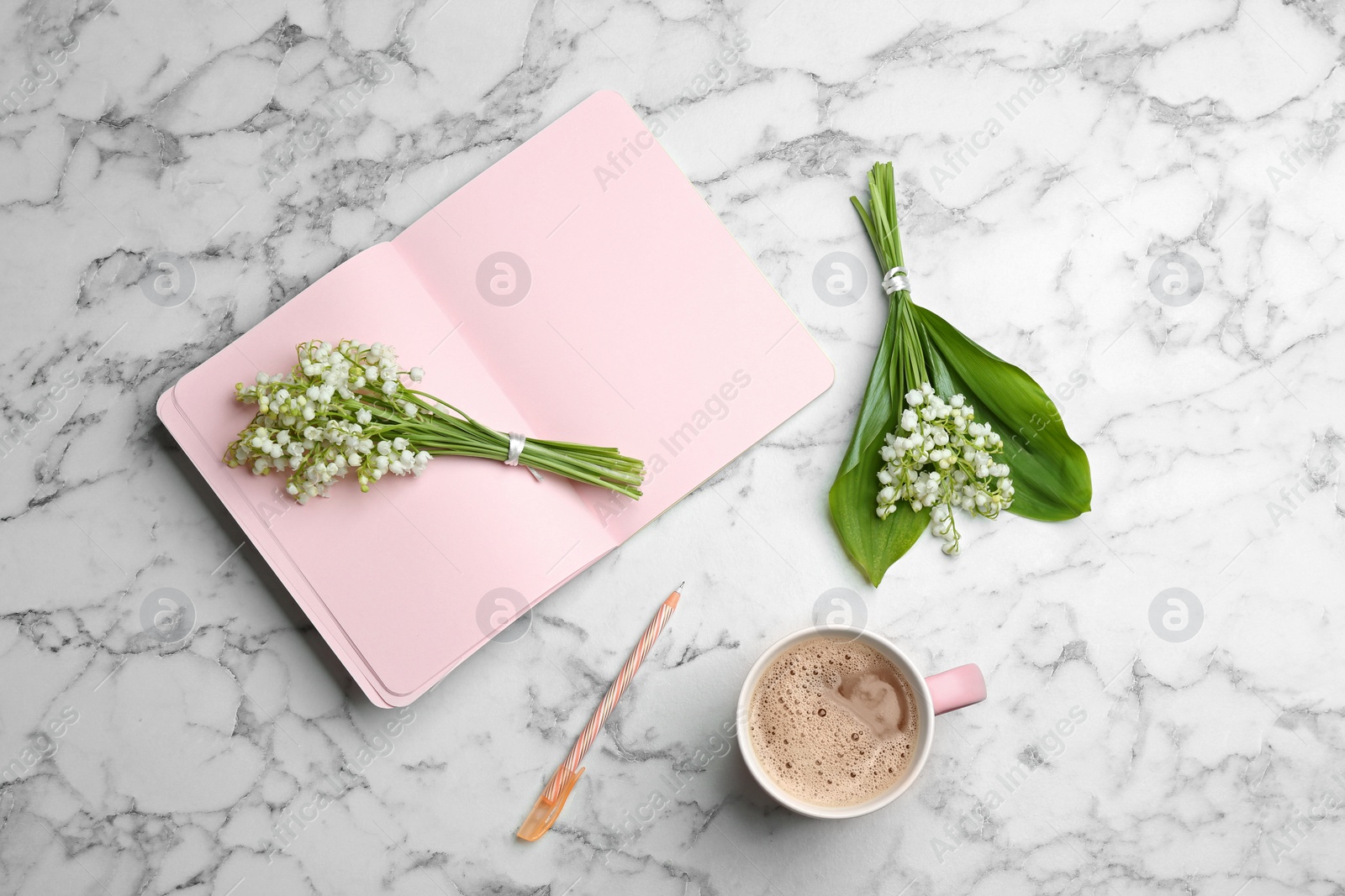 Photo of Flat lay composition with notebook, lily of the valley bouquets and coffee on marble background. Space for text