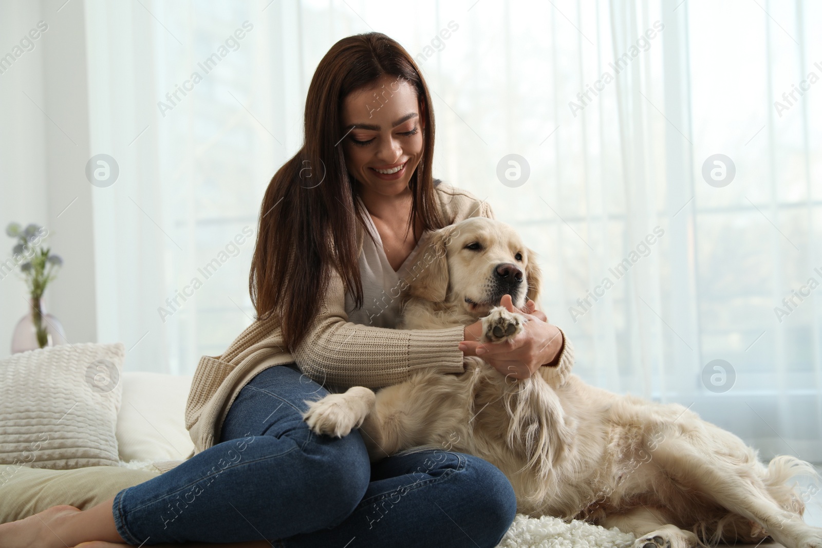 Photo of Young woman and her Golden Retriever at home. Adorable pet