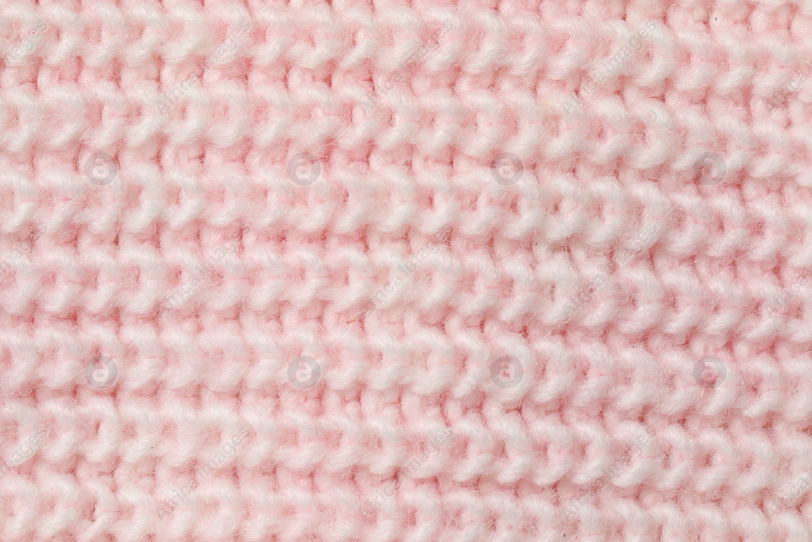 Photo of Texture of soft pink knitted fabric as background, top view