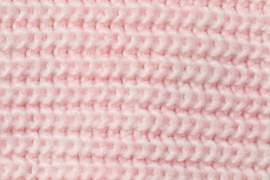 Photo of Texture of soft pink knitted fabric as background, top view