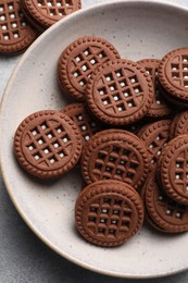 Photo of Tasty chocolate sandwich cookies with cream on light grey table, top view