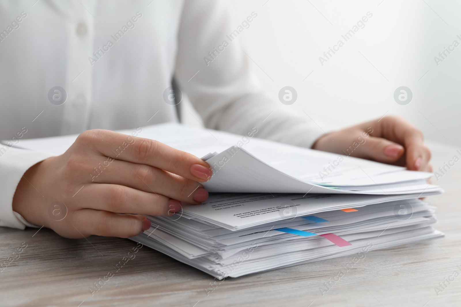 Photo of Woman reading documents at wooden table in office, closeup. Space for text