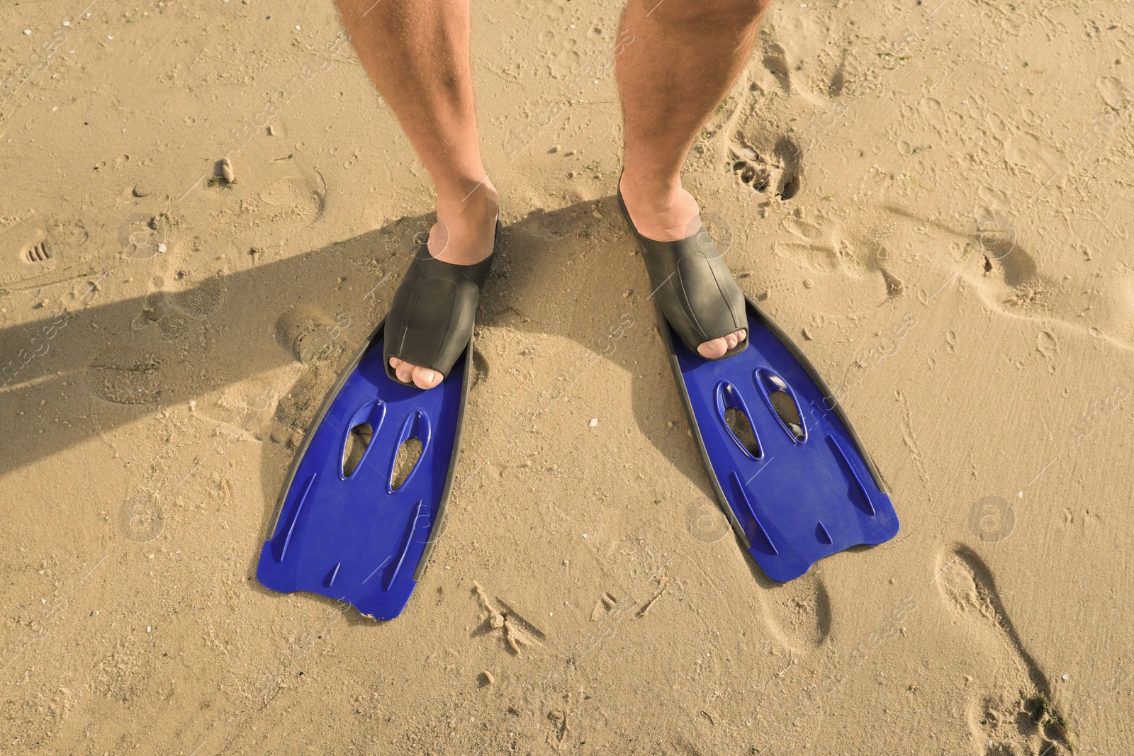 Photo of Man in flippers on wet sand, closeup