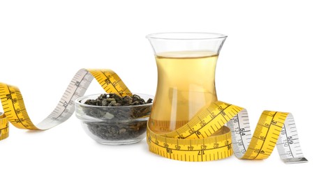 Photo of Diet herbal tea, dry leaves and measuring tape on white background