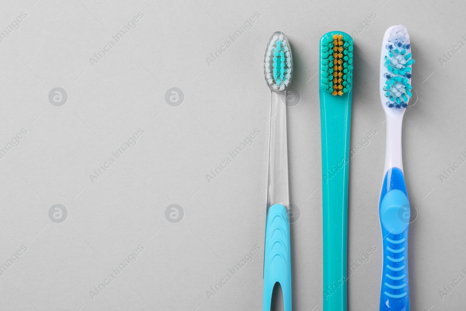 Photo of Many different toothbrushes on light background, flat lay. Space for text