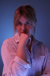 Photo of Portrait of beautiful young woman on color background with neon lights