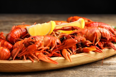 Delicious boiled crayfishes on wooden table, closeup