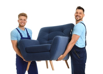 Portrait of moving service employees with armchair on white background