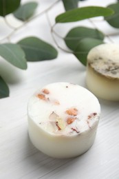 Photo of Soap bar and green leaves on white wooden table. Eco friendly personal care product