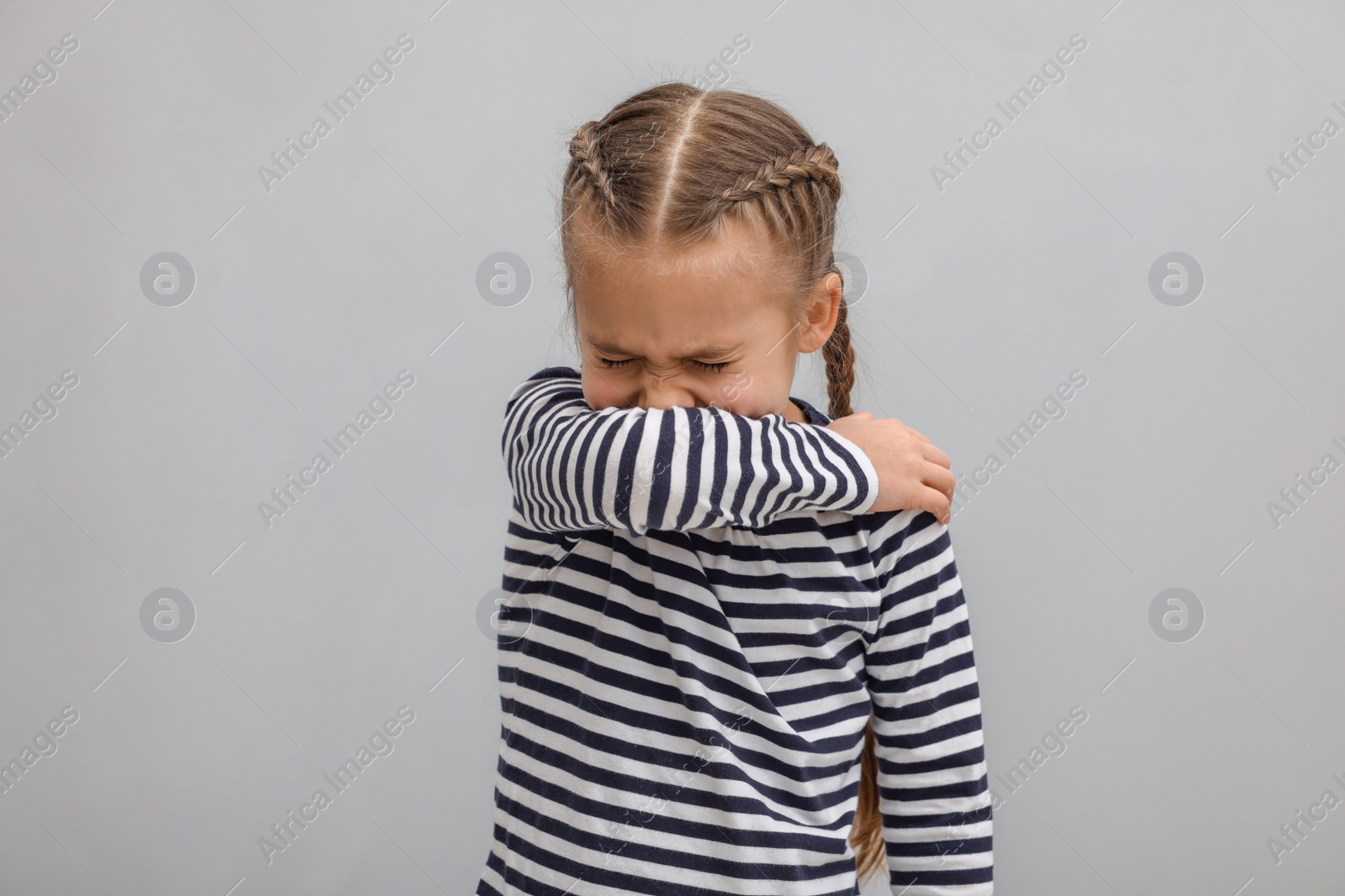 Photo of Sick girl coughing on gray background. Cold symptoms