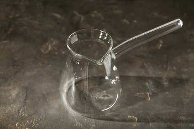 Photo of Empty glass turkish coffee pot on grey table
