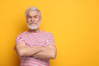 Senior man with mustache on orange background, space for text