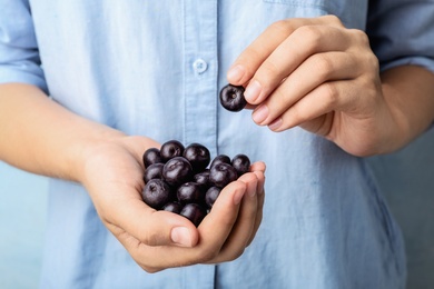 Photo of Female holding fresh acai berries, closeup view