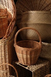 Many different wicker baskets made of natural material as background, closeup