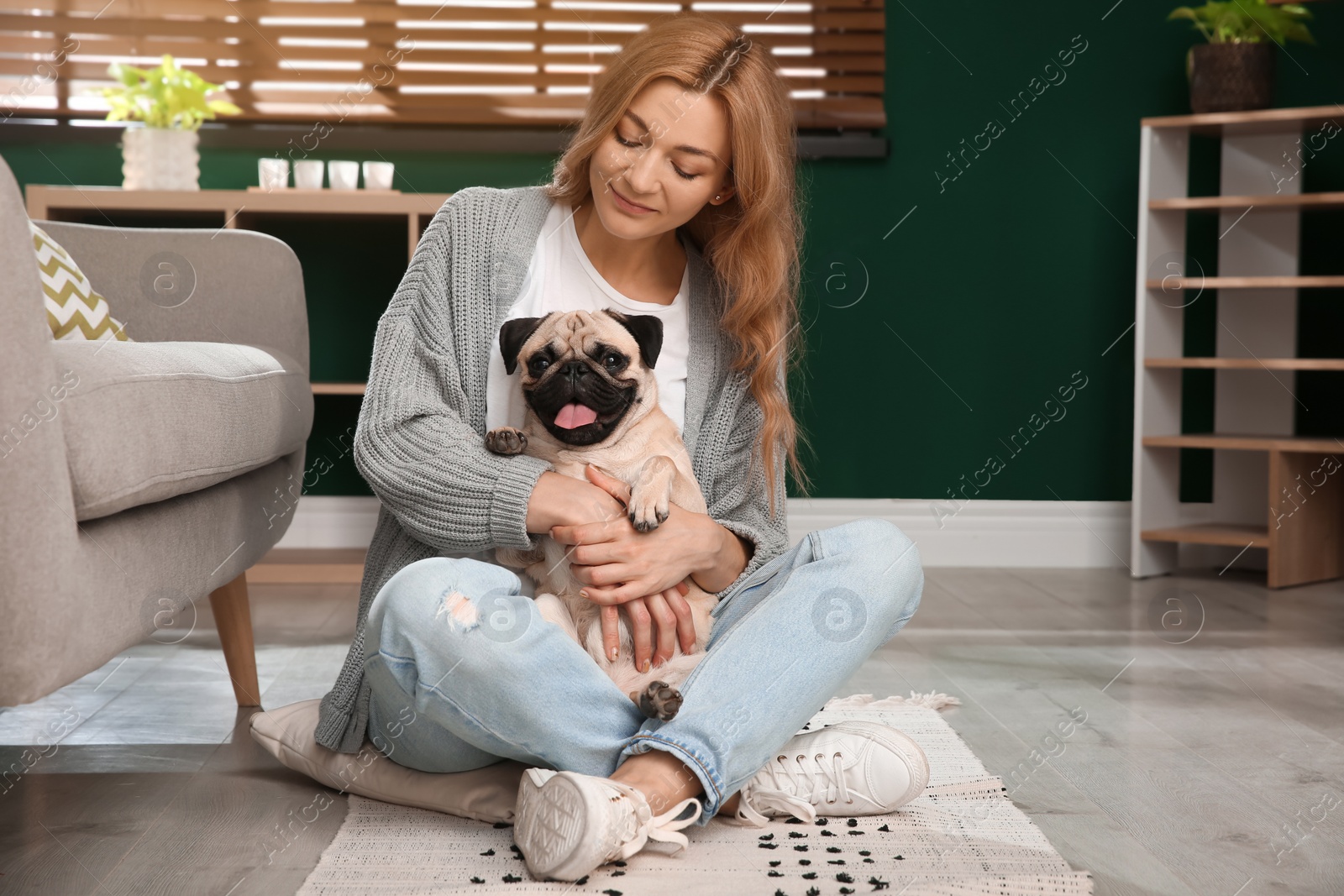 Photo of Woman with cute pug dog at home. Animal adoption