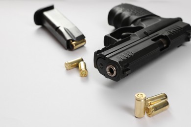 Handgun, magazine and bullets on white background