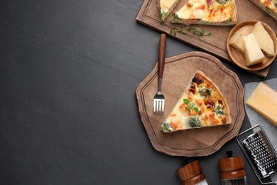 Photo of Pieces of delicious homemade salmon quiche with broccoli, cheese and fork on black table, flat lay. Space for text