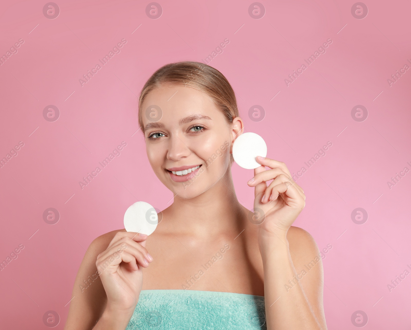 Photo of Beautiful young woman with cotton pads on pink background