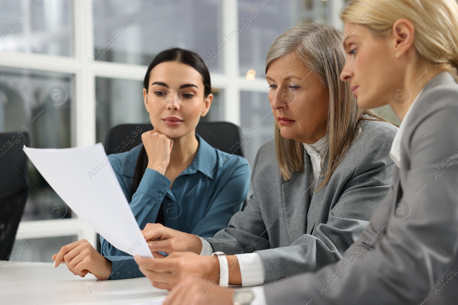 Photo of Lawyers working together with documents at table in office