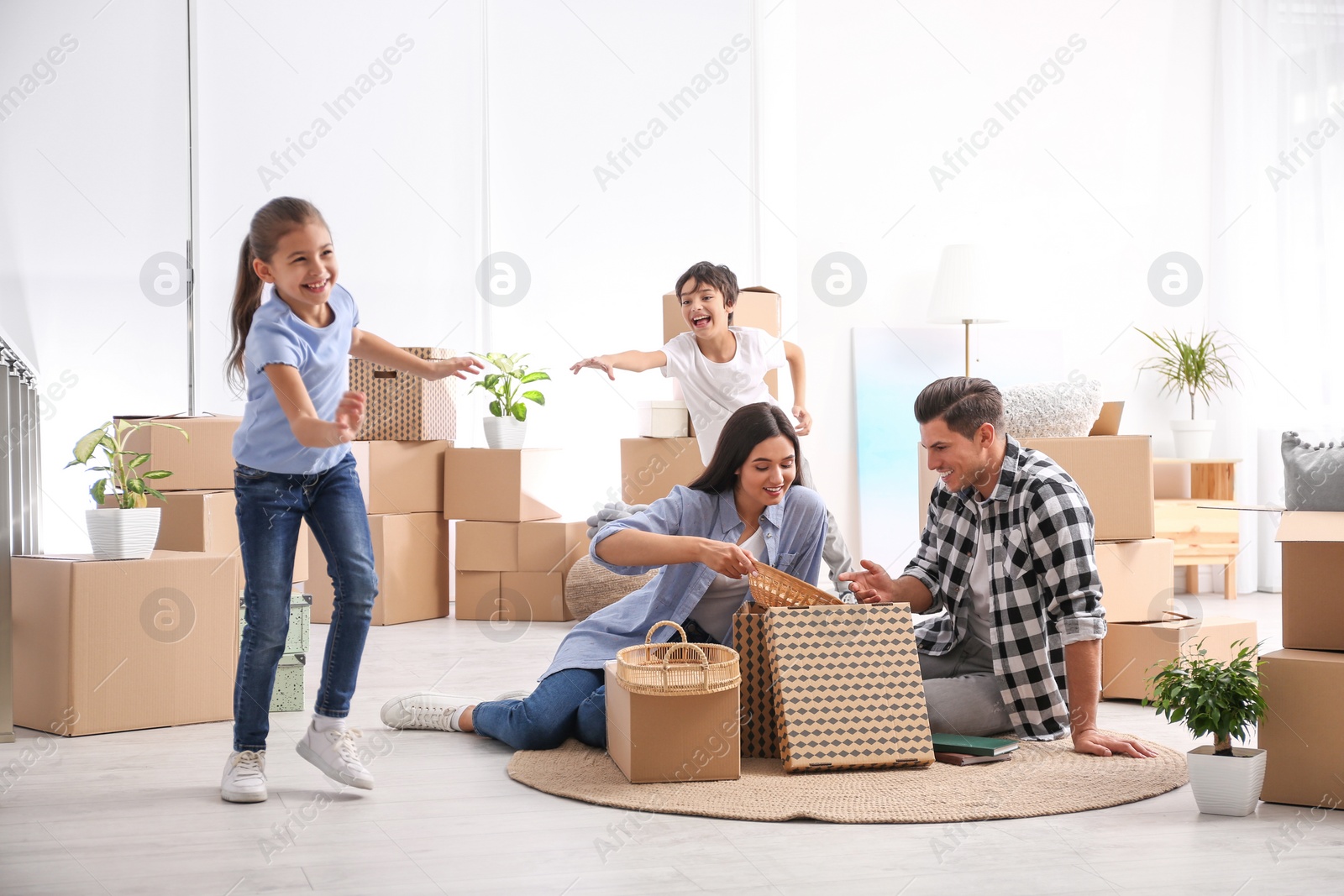 Photo of Happy family unpacking moving boxes at their new home