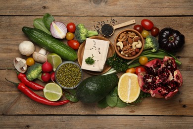 Photo of Different vegetables on wooden table, flat lay. Vegan diet