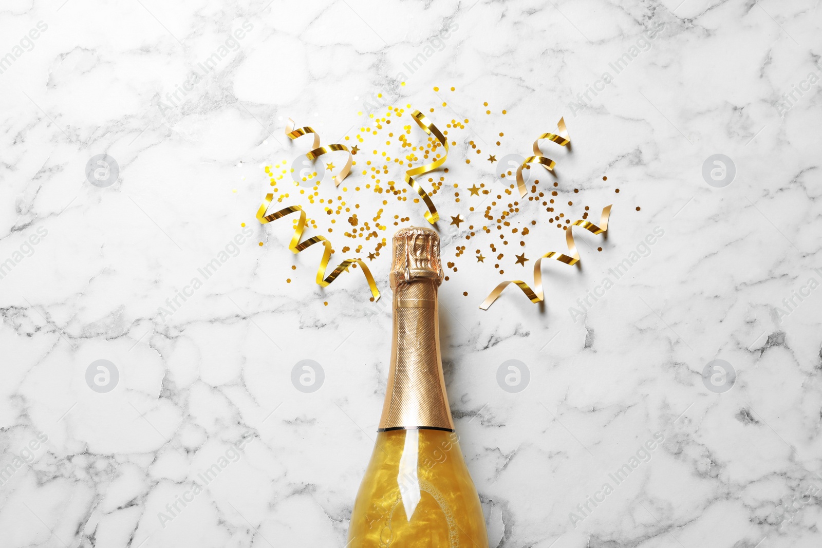 Photo of Flat lay composition with bottle of champagne for celebration on white marble background