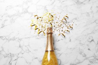 Photo of Flat lay composition with bottle of champagne for celebration on white marble background