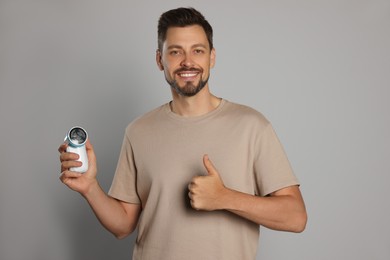 Photo of Handsome man holding fabric shaver on light grey background