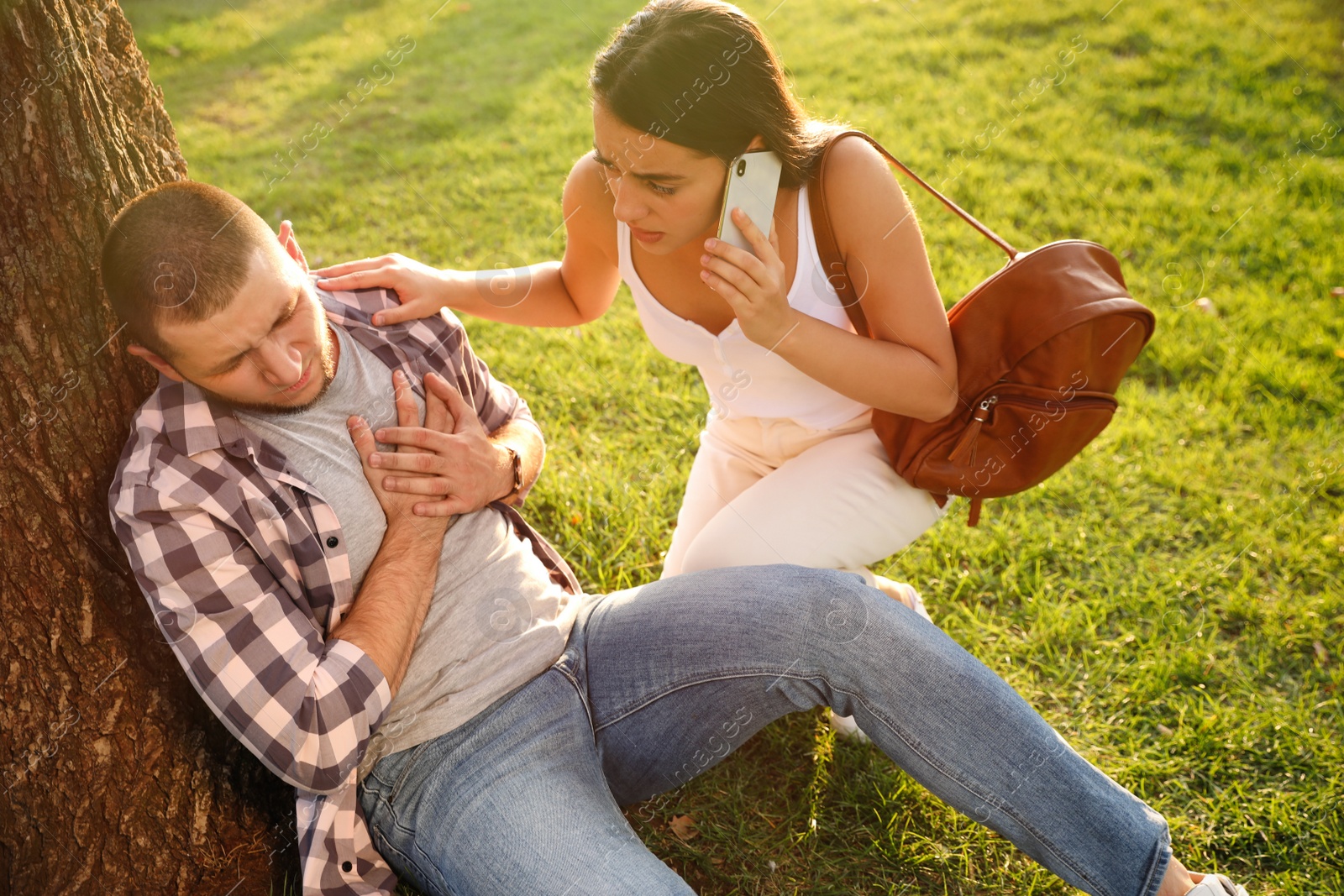 Photo of Woman calling ambulance to help man with heart attack in park