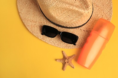 Photo of Flat lay composition with bottle of sunscreen on yellow background