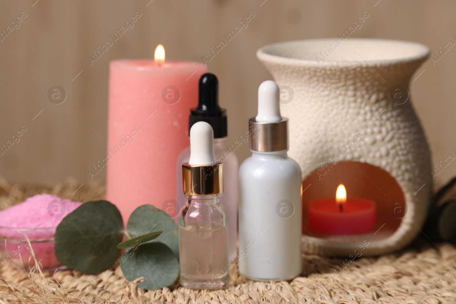 Photo of Different aromatherapy products, burning candles and eucalyptus leaves on table, closeup