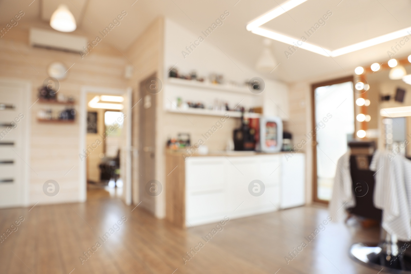 Photo of Blurred view of stylish barbershop interior with professional hairdresser's workplace