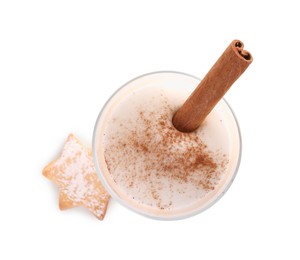 Photo of Delicious eggnog with cinnamon in glass and cookie isolated on white, top view