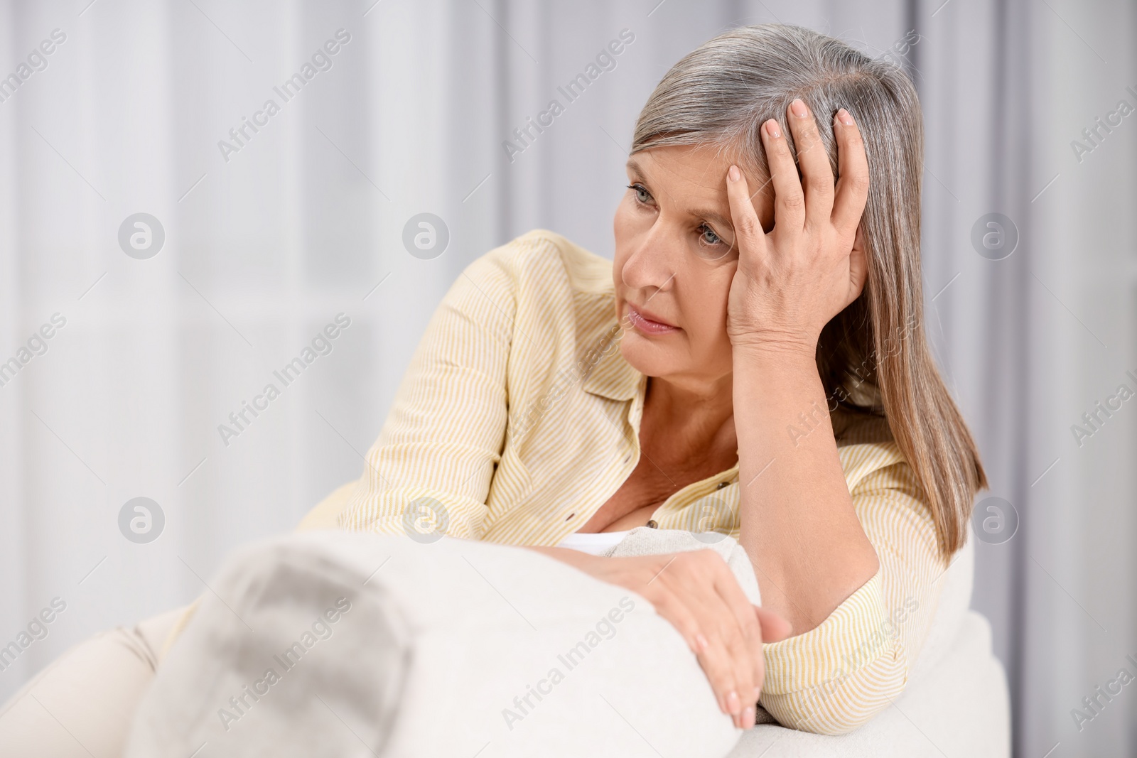 Photo of Menopause, mood changes. Sad woman on sofa at home