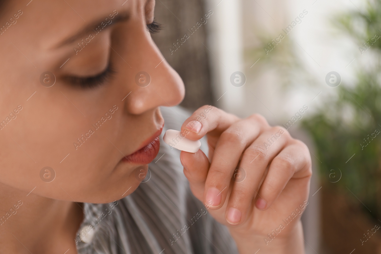 Photo of Young woman taking abortion pill at home, closeup