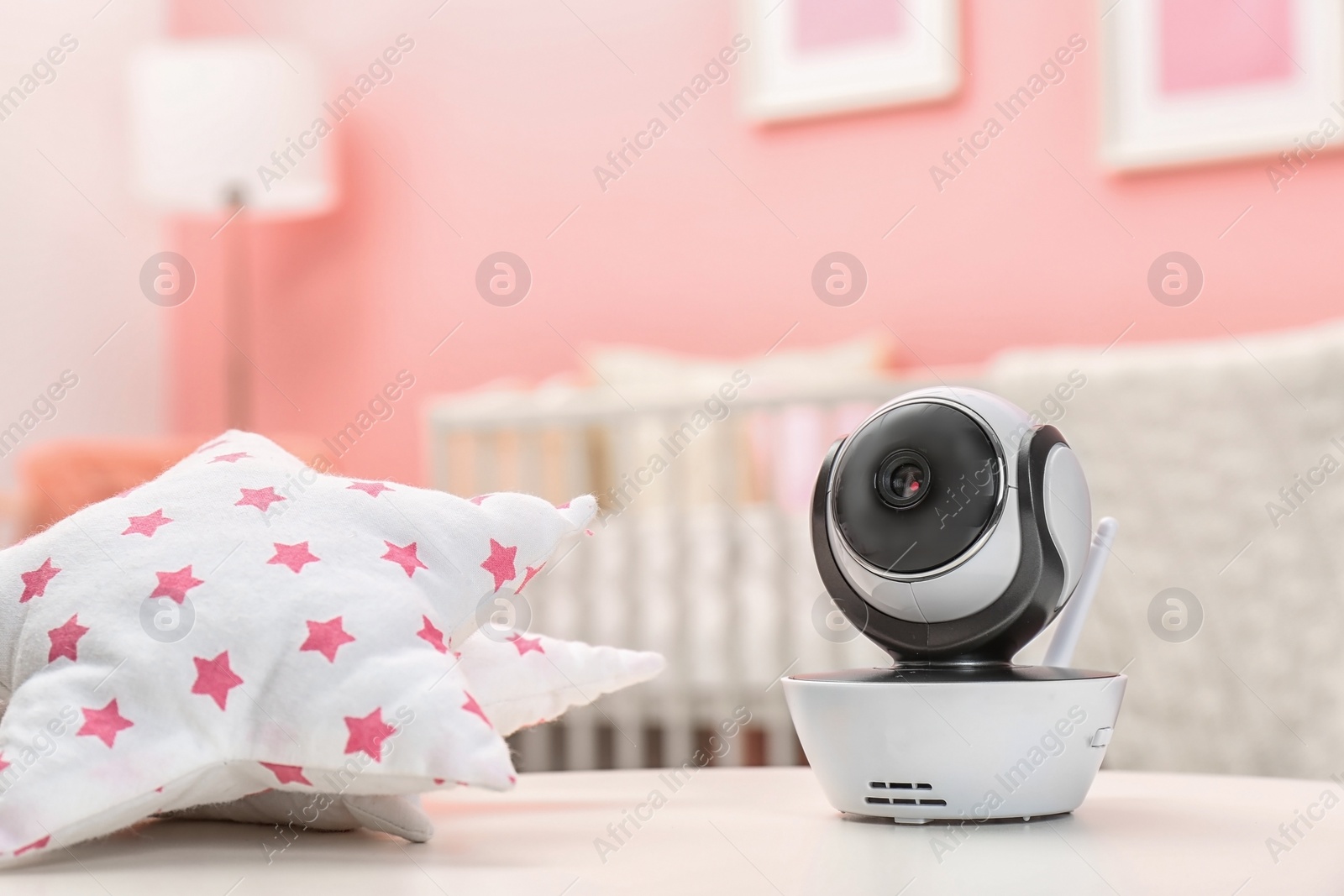 Photo of Baby monitor and toy on table in room, space for text. CCTV equipment