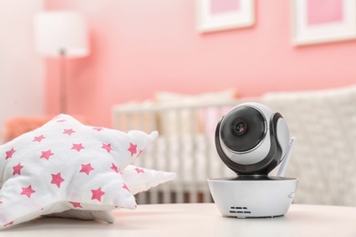 Baby monitor and toy on table in room, space for text. CCTV equipment