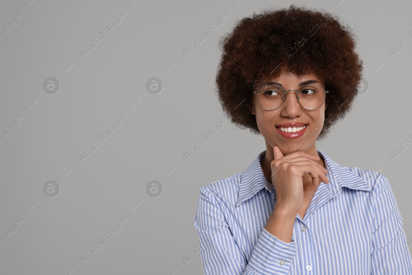 Photo of Portrait of happy young woman in eyeglasses on grey background. Space for text