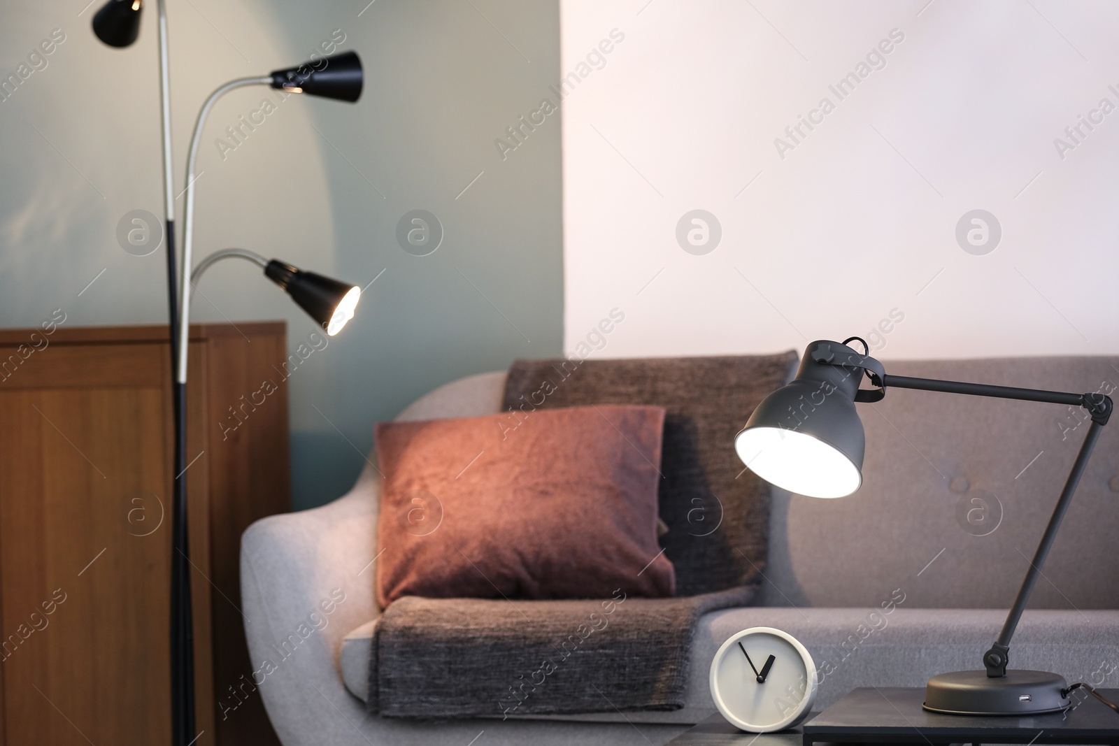 Photo of Modern living room interior with lamps and comfortable sofa