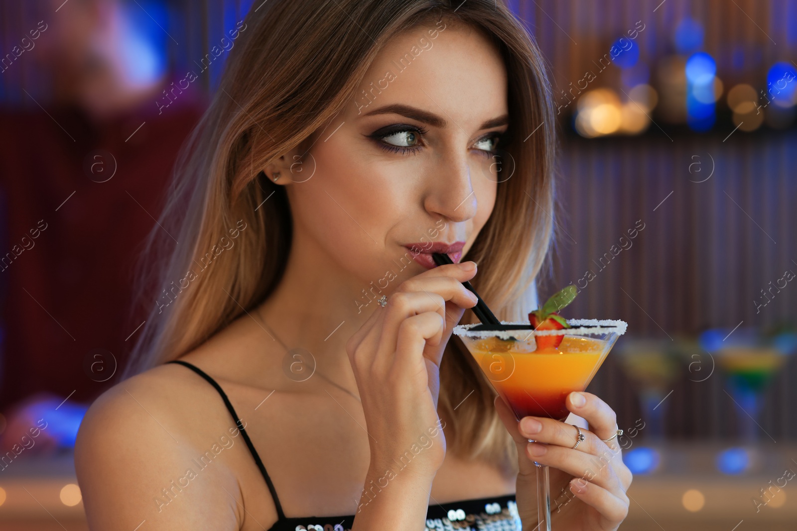 Photo of Beautiful young woman with glass of martini cocktail in bar