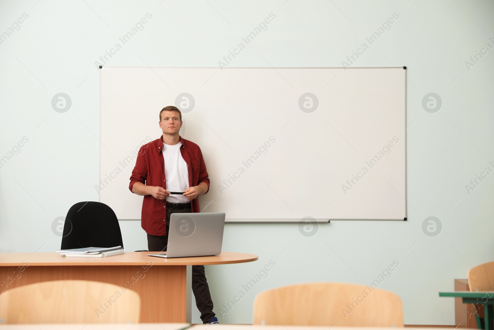 Photo of Male teacher near whiteboard in modern classroom