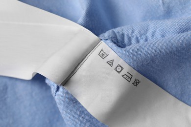 Photo of Clothing labels on light blue garment, closeup
