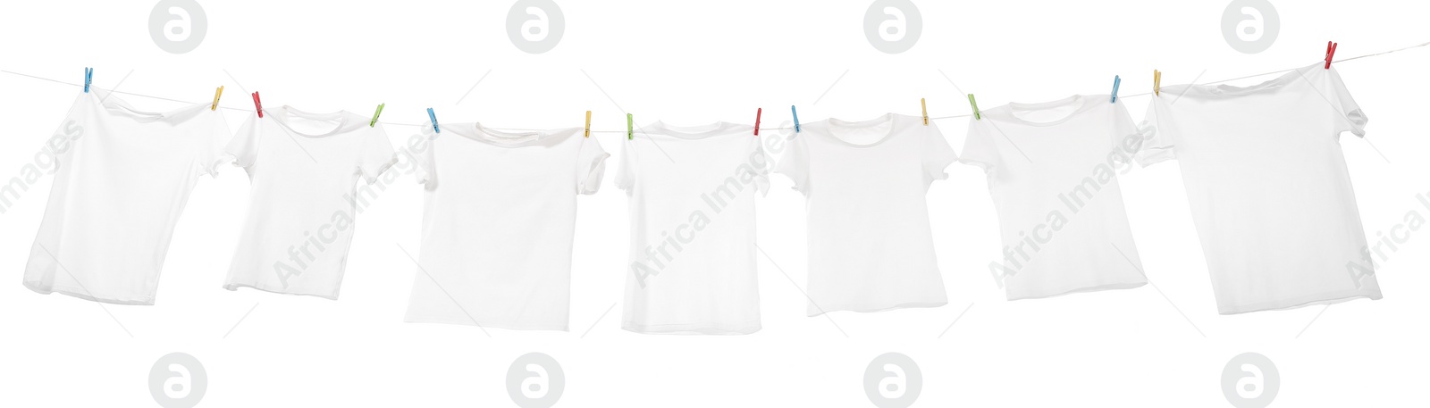 Photo of Many t-shirts drying on washing line isolated on white