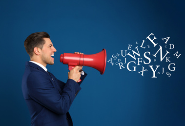 Image of Handsome man with megaphone and letters on blue background. Speech therapy concept