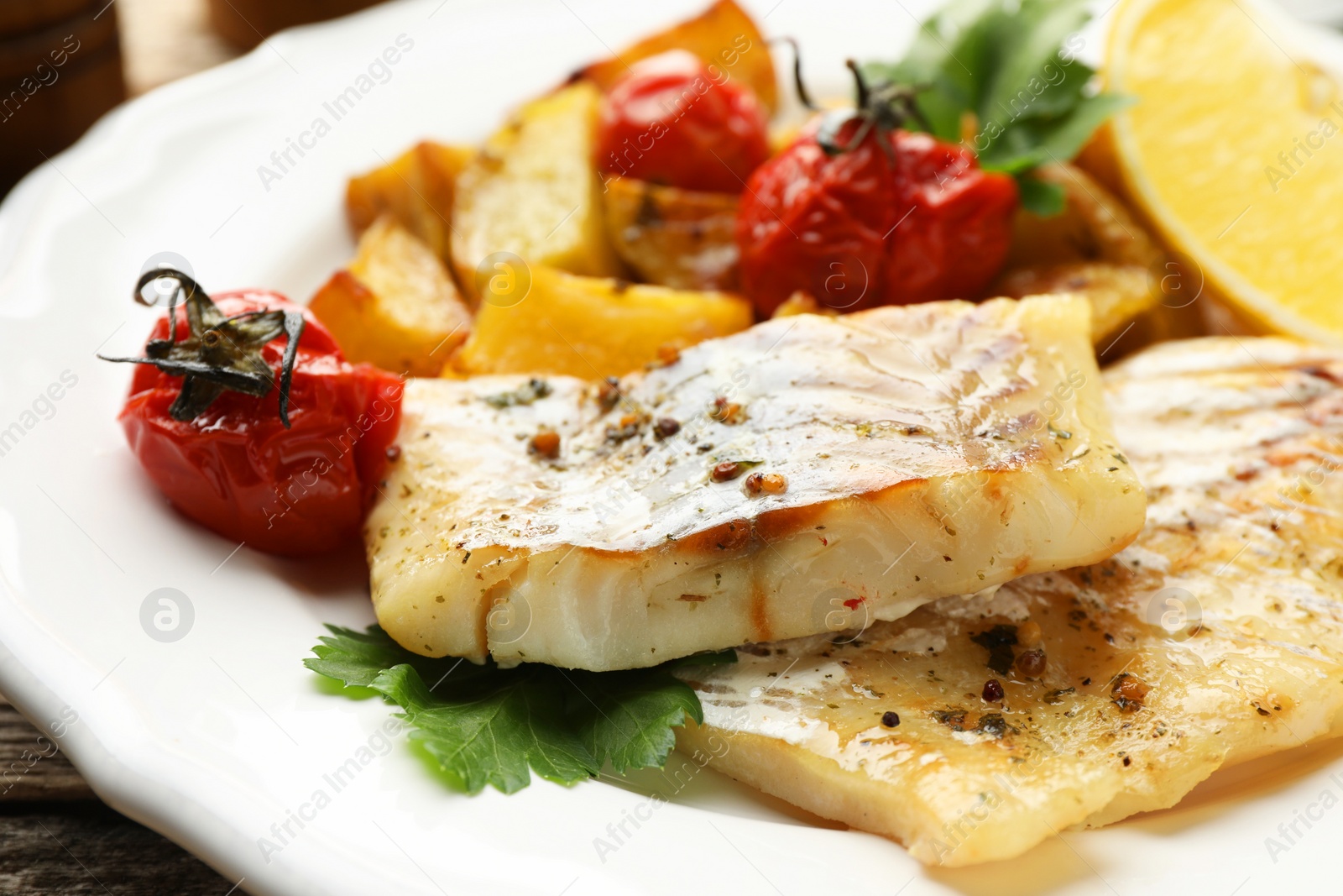 Photo of Tasty cod cooked with vegetables on table, closeup